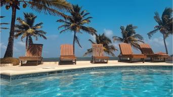 wooden pool chairs along the edge of a pool